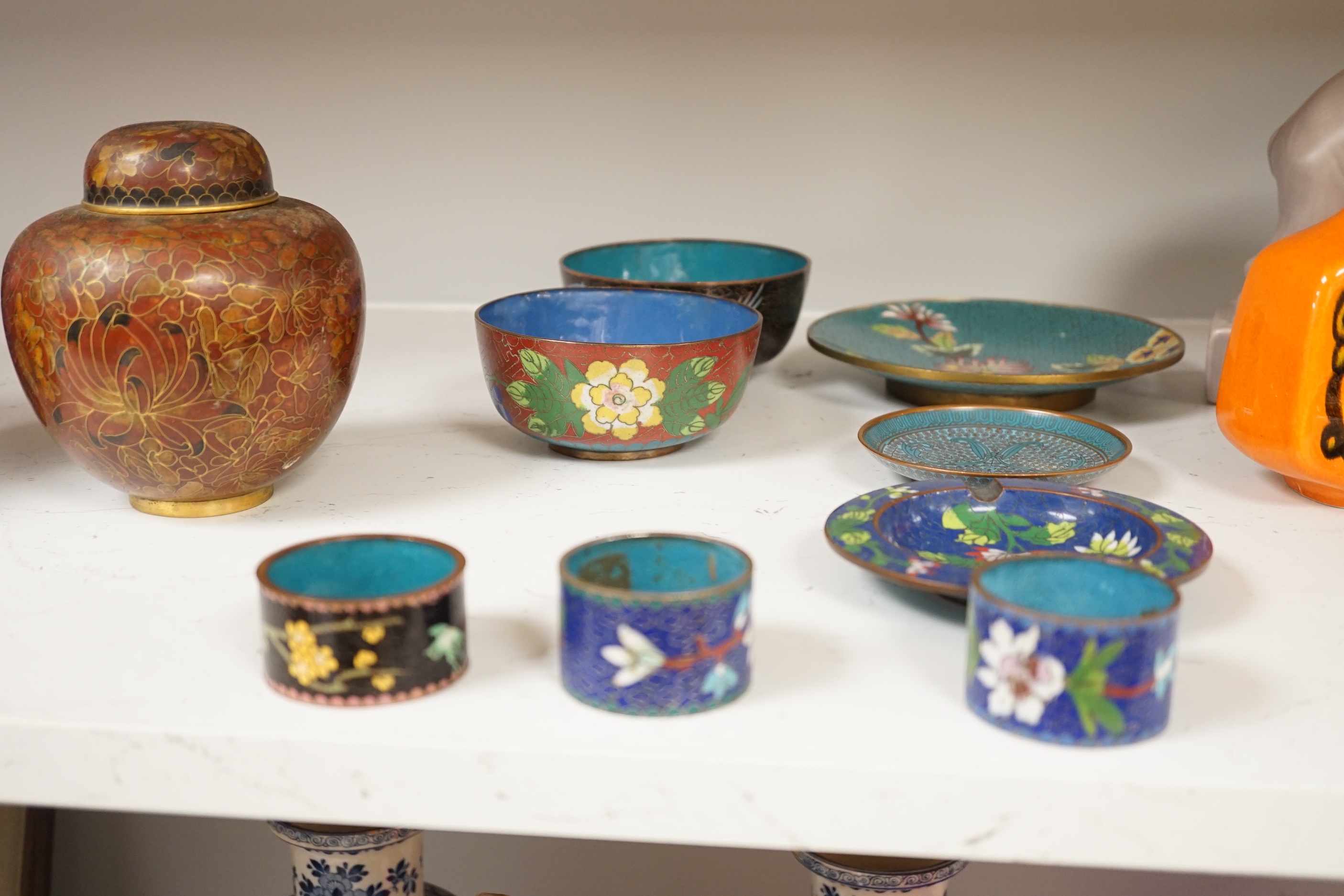 A collection of Chinese and Japanese cloisonné enamel pieces, including five vases, a ginger jar and cover, three bowls, a miniature teapot, napkin rings, etc. (19)